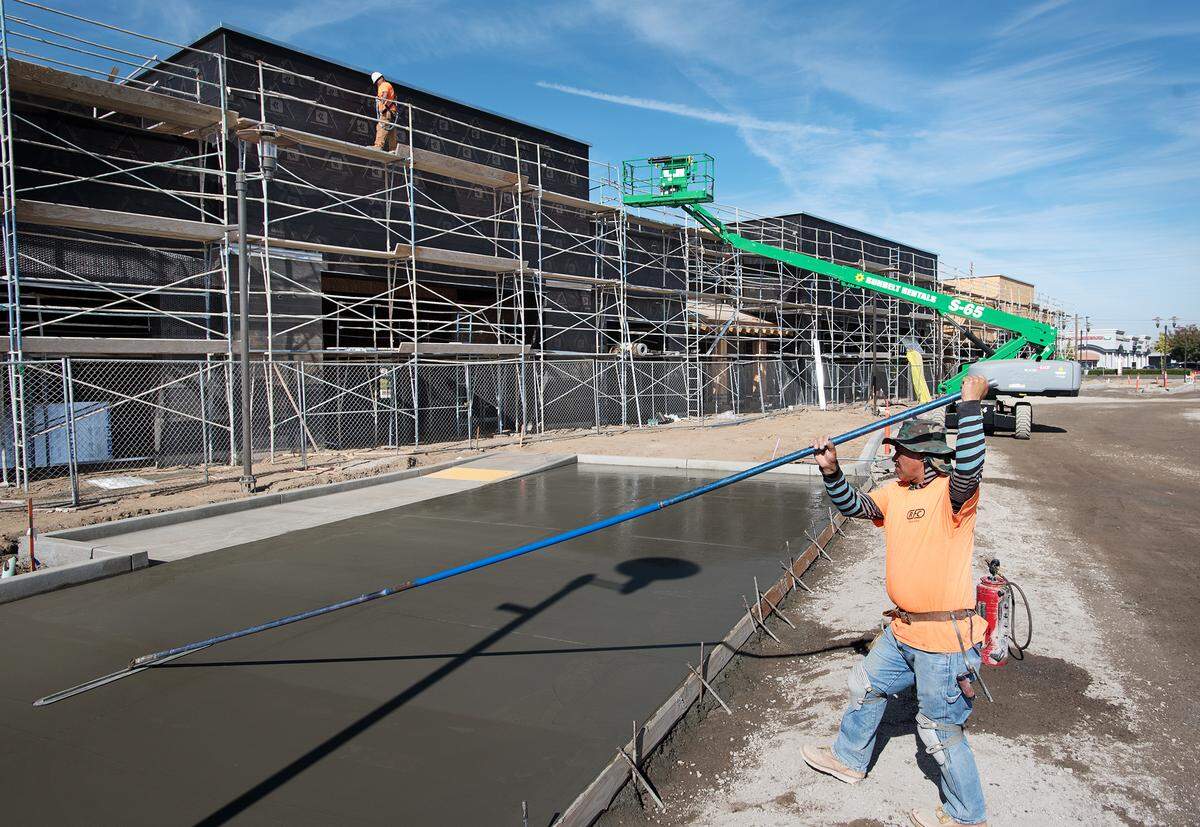 Hector Calderon finishes a concrete pad at the site of The Marketplace retail development on Oakdale Road in Modesto, Calif., on Thursday, Nov. 1, 2018. 