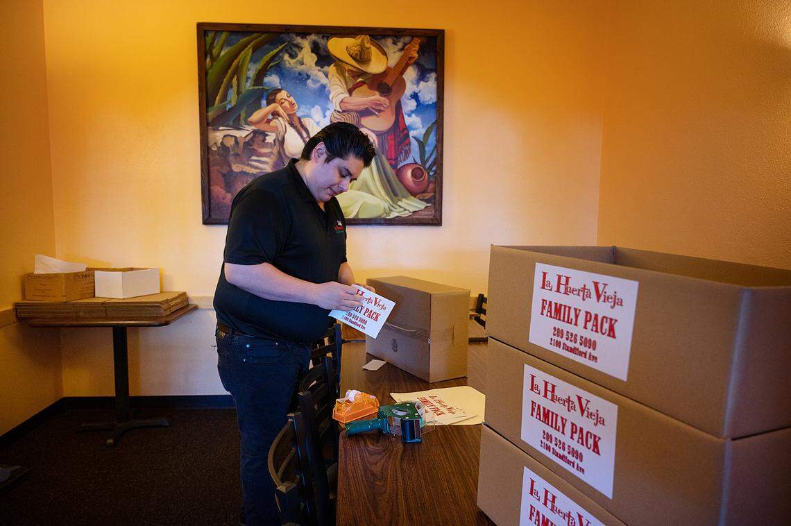 Franky Acosta prepares family pack take-out boxes at La Huerta Vieja restaurant in Modesto, Calif., on Friday, May 13, 2022. Acosta says they do want to use food delivery services but offer curbside take-out for their customers.