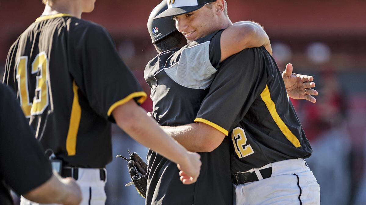 Hughson pitcher Luke Madsen gets a hug from coach Charly Garza after closing out the final inning in the game with Ripon at Ripon High School in Ripon, Calif., Tuesday, May 7, 2019.