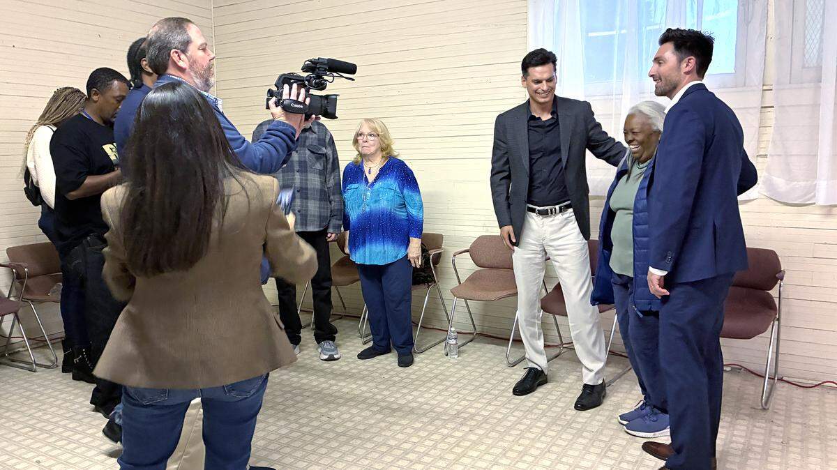 A man holding a video camera points it towards supervisor Condit and gubernatorial candidate Calderon as well a resident, Bettie Yelder.