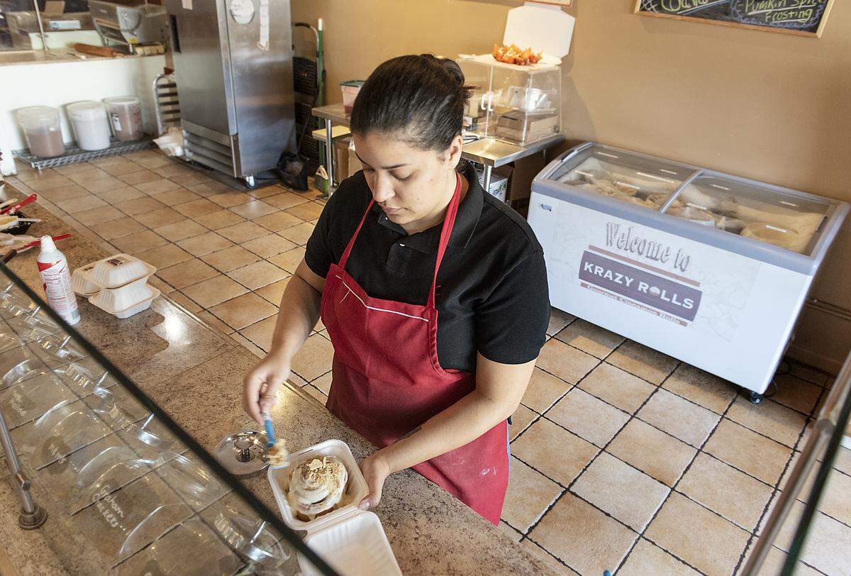Taylor Kamakeeaina dresses a cinnamon roll at Krazy Rolls in downtown Modesto, Calif., Tuesday, Oct. 15, 2019.