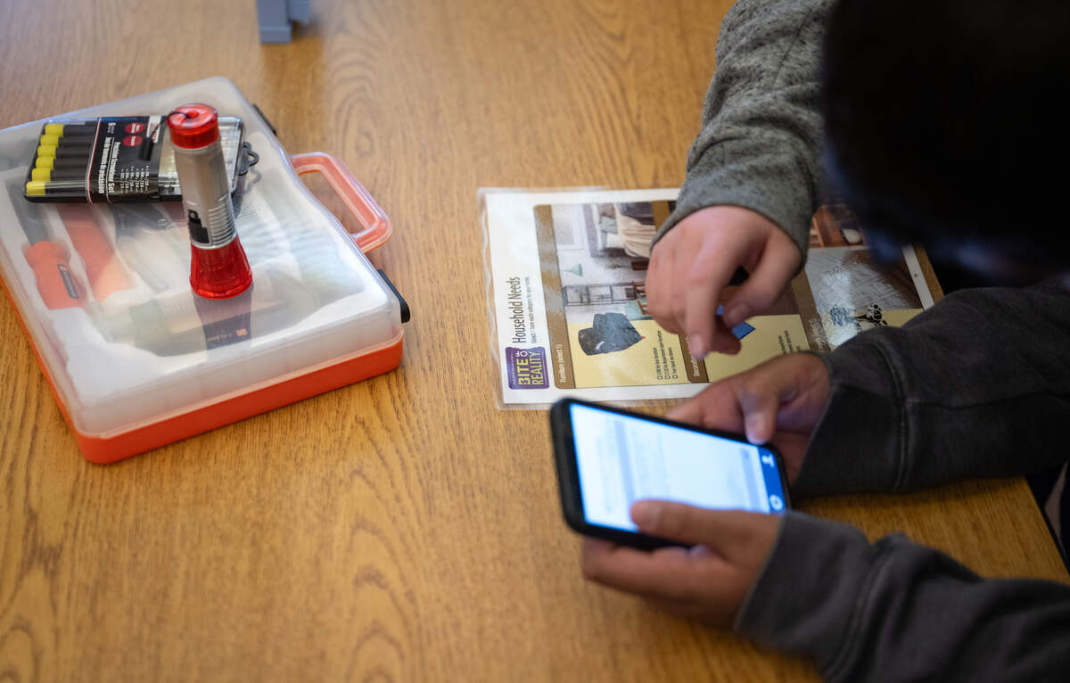 7th and 8th grade students use the Bite of Reality smartphone app to participate in an after school financial literacy event at Glick Middle School in Empire, Wednesday, Dec. 11, 2024.