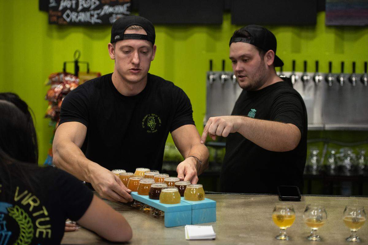Brew master Cory Onken, left, and co-owner Matt McCracken serve up fights of beer at Grains of Virtue Brewing Company in Oakdale, Calif., on Thursday Oct. 23, 2020.