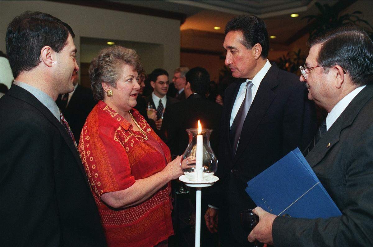 Henry J. Cisneros, former Secretary of HUD, talks with former Modesto Mayor Carol Whiteside as Modesto residents Raul Garcia, left, and Dale Butler, right, look on during social hour prior to the official program of the Stanislaus County Hispanic Chamber of Commerce banquet Saturday night at the Modesto Centre Plaza.