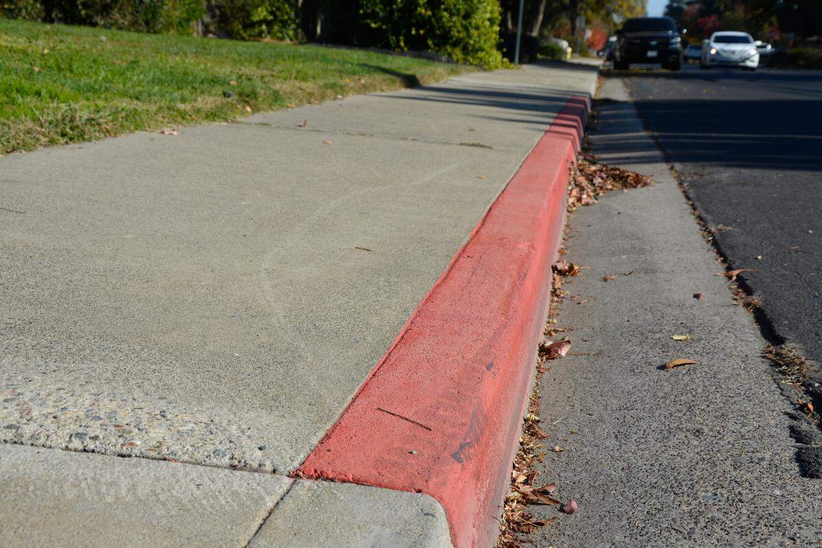 Sections of the curb along Veneman Avenue in north Modesto shown painted red Nov. 28, 2023.