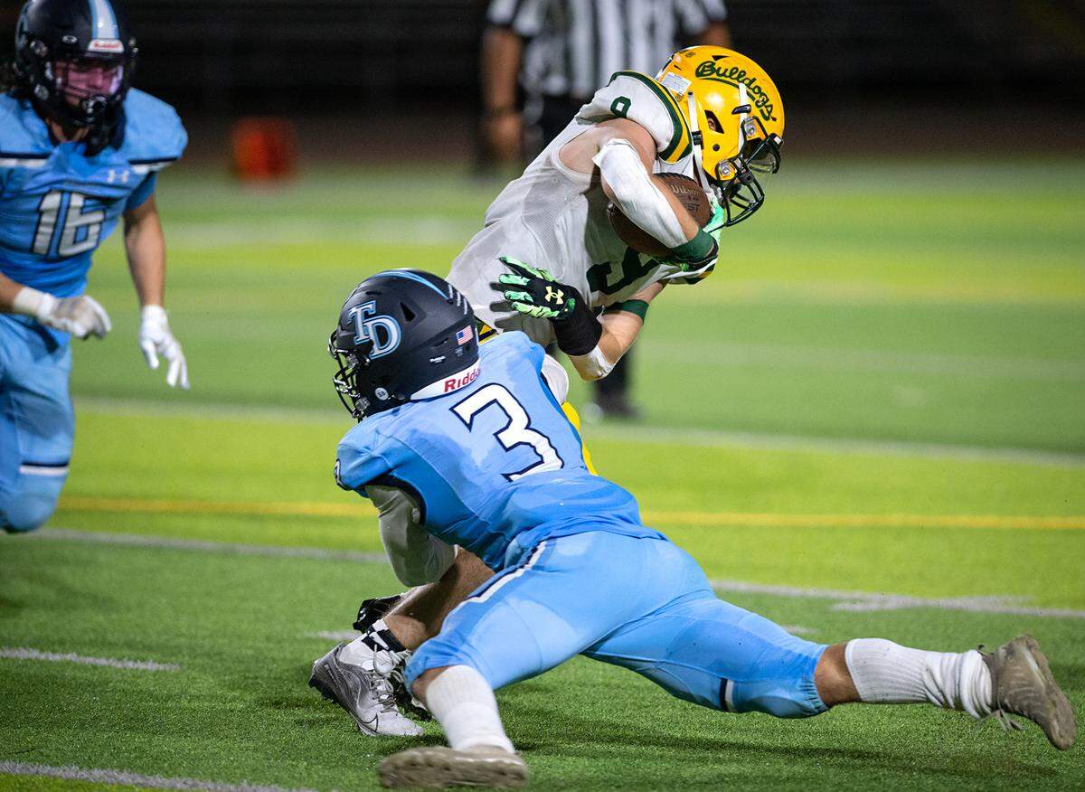 Downey’s Cayden Edmiston stops Tracy’s Tommy Hayes at the line on a fourth down run play during the nonleague game at Downey High School in Modesto, Calif., on Friday, September 16, 2022.