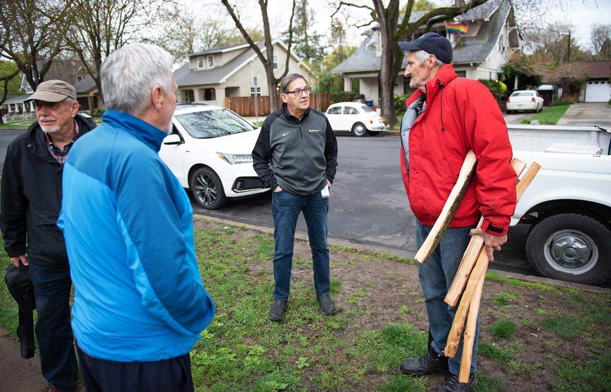 Modesto councilmember Nick Bavaro, middle, talks with Gary McNeil, right, what has been living in his truck in Modesto, Calif., Wednesday, March 29, 2023. Bavaro, 70, relies on homeless advocates Frank Ploof, second left, and Eric Caine as his guides in meeting and talking with homeless people.