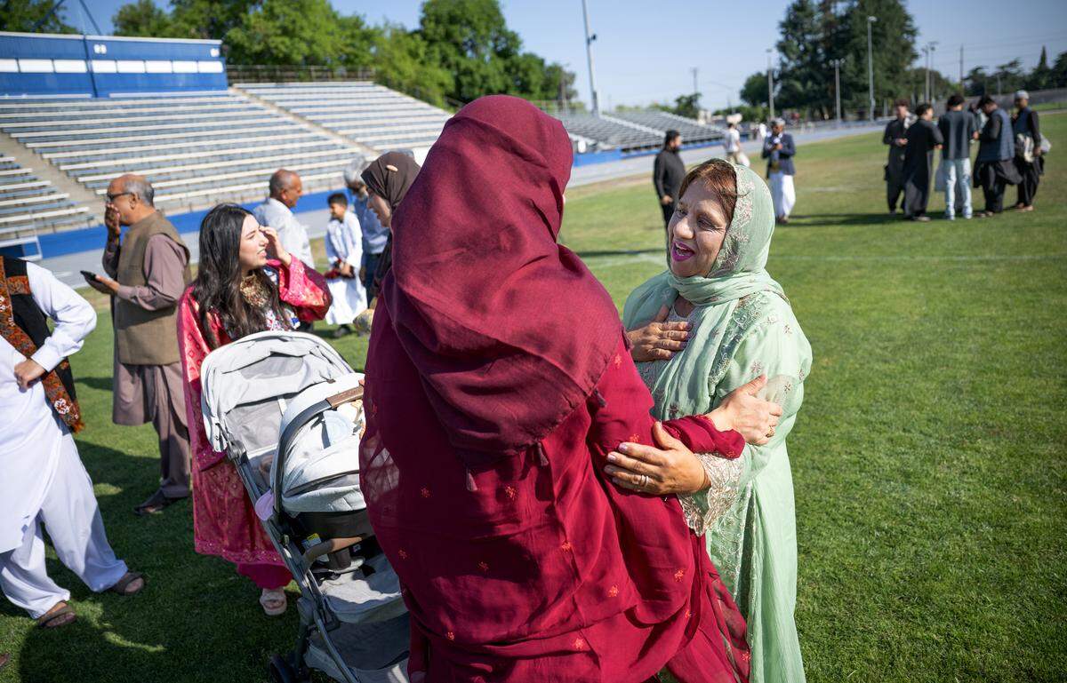 Nariman Khattak, right, greets a friend after a Muslim community Eid prayer at Modesto Junior College in Modesto, Thursday, June 6, 2025.