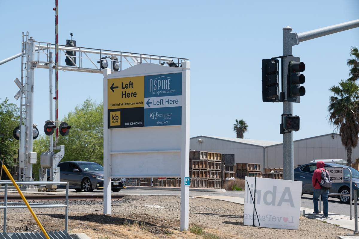 Directional signs on Walnut Avenue point to new homes being built as part of the Villages of Patterson development in northeast Patterson, Calif., on Tuesday, April 12, 2022.