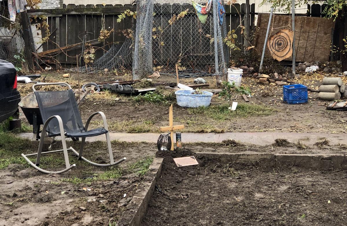 A cross marks the area where a body was found by someone attempting to bury a pet Saturday in the backyard of a home on the 100 block of Santa Rita Avenue in Modesto, Calif. The site is pictured on Wednesday November 28, 2018.