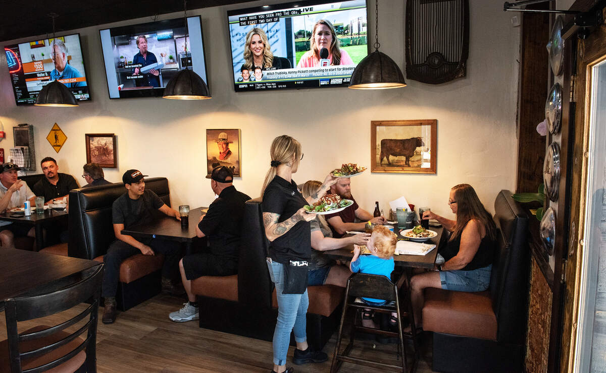 Manager Leigh Genova delivers food to customers at Ranch Hand restaurant in Hughson, Calif., on Thursday, July 28, 2022.