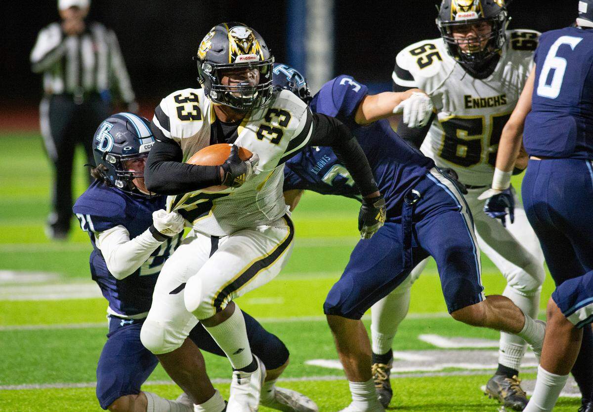 Enochs’s Abayomi Babalola runs the ball during the Central California Athletic League game with Downey at Downey High School in Modesto, Calif., on Friday, March 26, 2021.