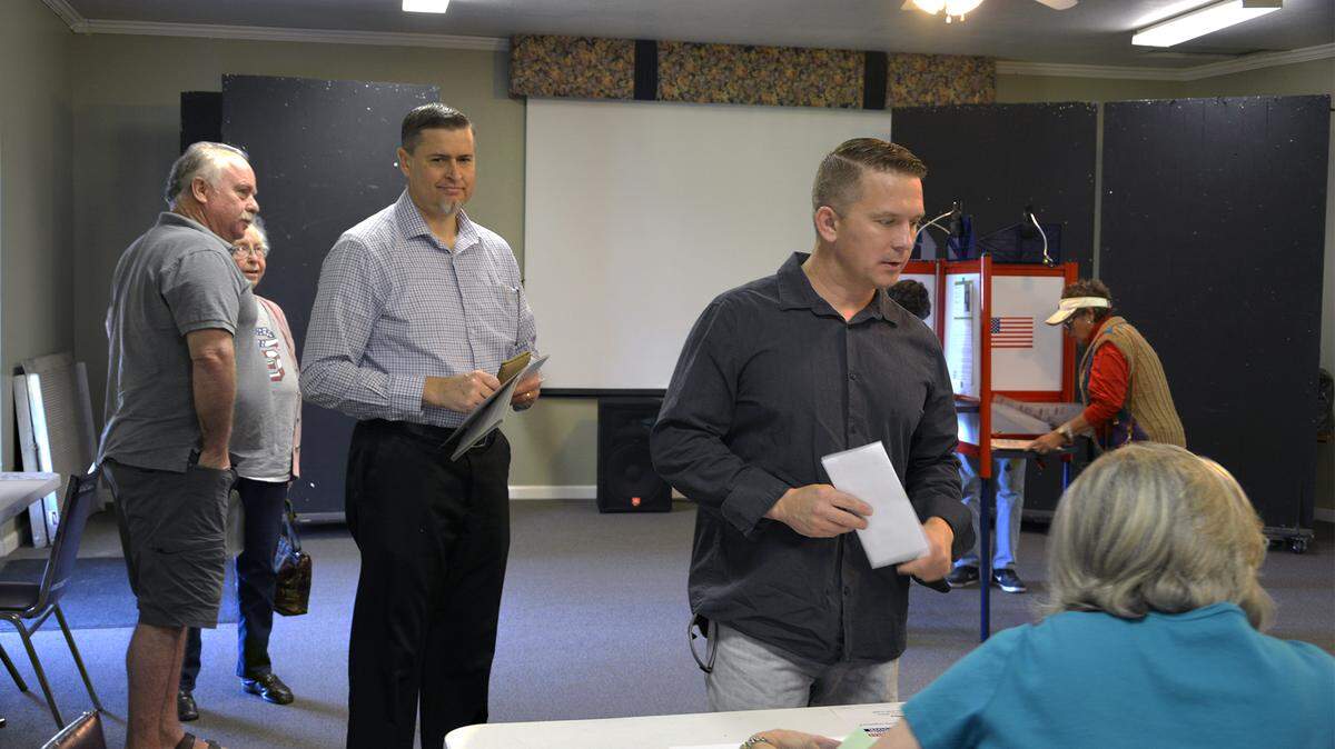 Voters approach poll workers to check in for voting Tuesday morning November 6, 2018 at North Modesto Church of God in Modesto, Calif.