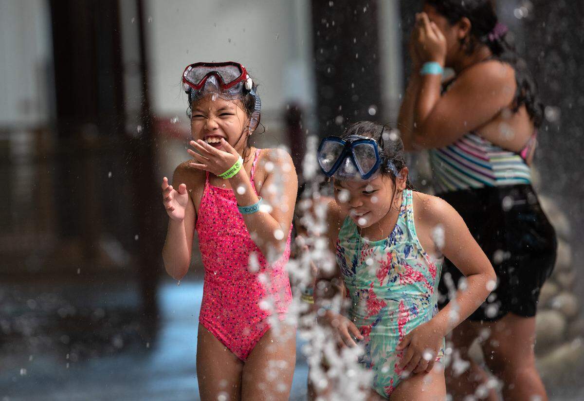Deanna Aquitania, 10, left, and her sister Denise, 5, enjoy the giant water splash at Great Wolf Lodge resort in Manteca, Calif., on Tuesday, June 29, 2021.