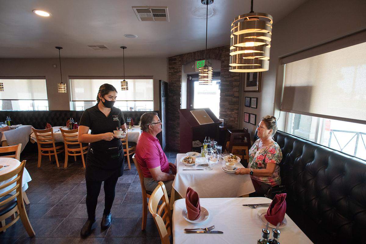 Nathaly Alonso serves diners Keri and Mark Langley of Oakdale at L’ Gusto Cucina Italiana in Riverbank, Calif., on Wednsday, July 21, 2021.