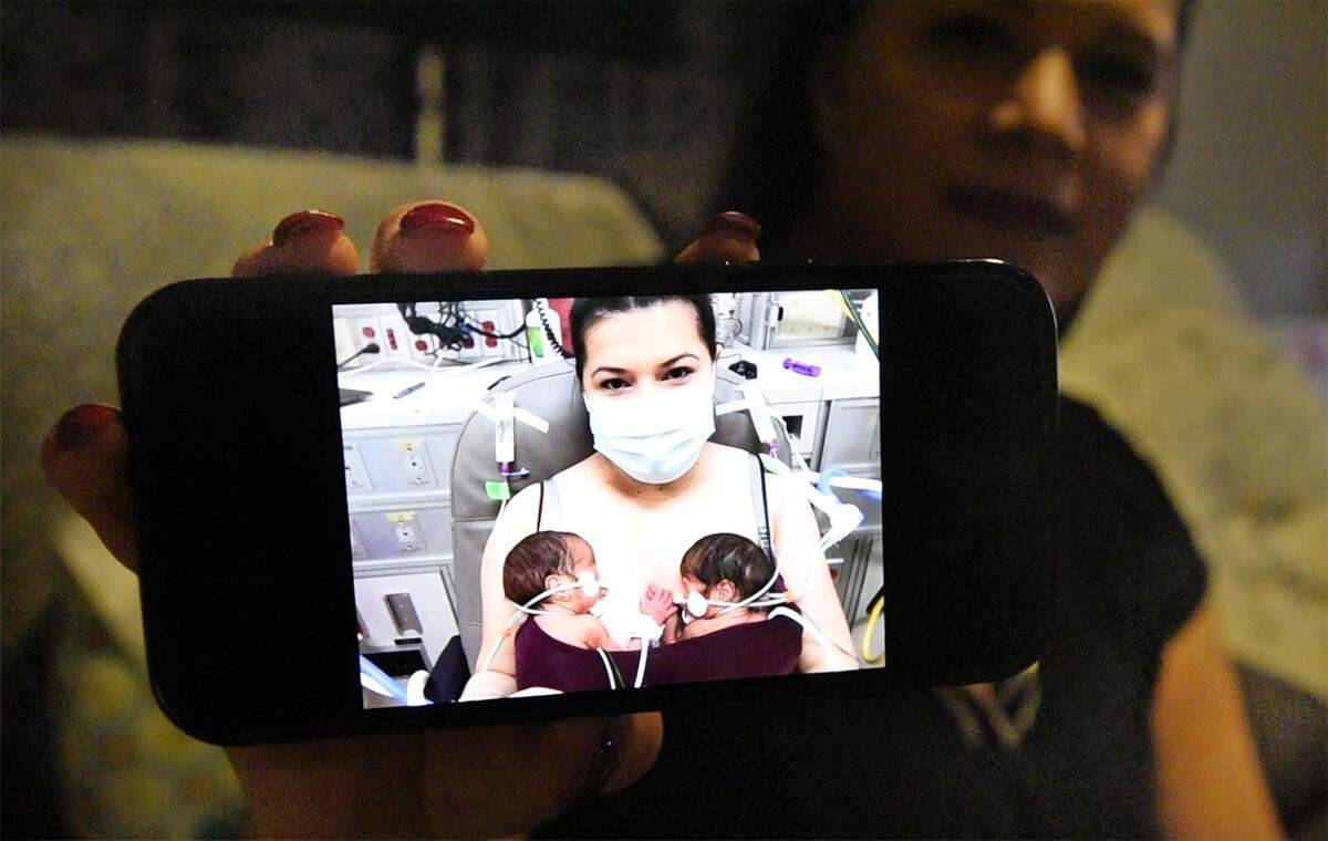 Tania Villanueva shows a picture of her with two of her boys, Sammy and Robert on Jan. 25, at Doctors Medical Center in Modesto. Tania and her husband Rene are parents to quadruplets who were born on Dec. 31, 2020. Photographed at their home east of Hughson, Calif., on Thursday, Dec. 16, 2021.