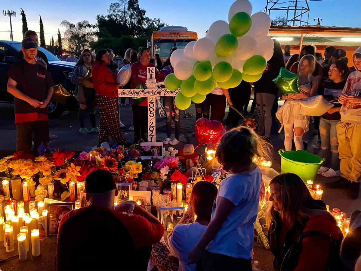 Family members of 16-year-old Evan Robinson sit in front of his memorial on Monday, May 3, 2021 in Keyes. Robinson was killed Sunday in a shootout at the intersection of Martha Avenue and 7th Street.
