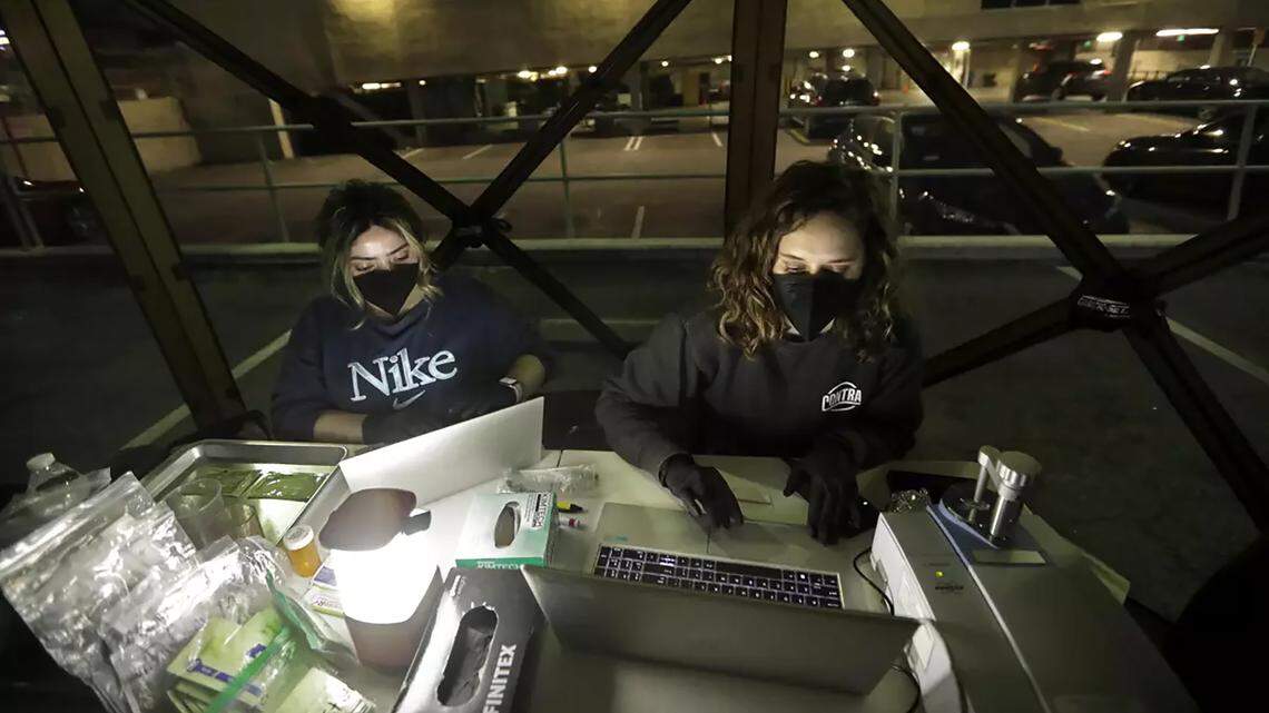 UCLA project director Ruby Romero, left, and project manager Caitlin Molina demonstrate in September 2024 how they test street drugs. Romero and Molina are part of a team of researchers from UCLA and other groups that released an analysis about an unfamiliar chemical called BTMPS now surfacing in the nation’s illicit drug supply.