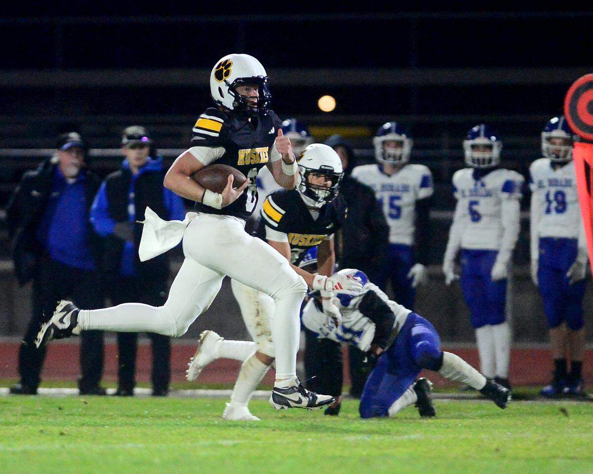 Hughson quarterback Robert McDaniel (8) scrambles up field a 2024 CIF Sac-Joaquin Section Division V Playoff game between Hughson High School and El Dorado High School at Hughson High School in Hughson California on November 15, 2024. Hughson won the game 28-6.