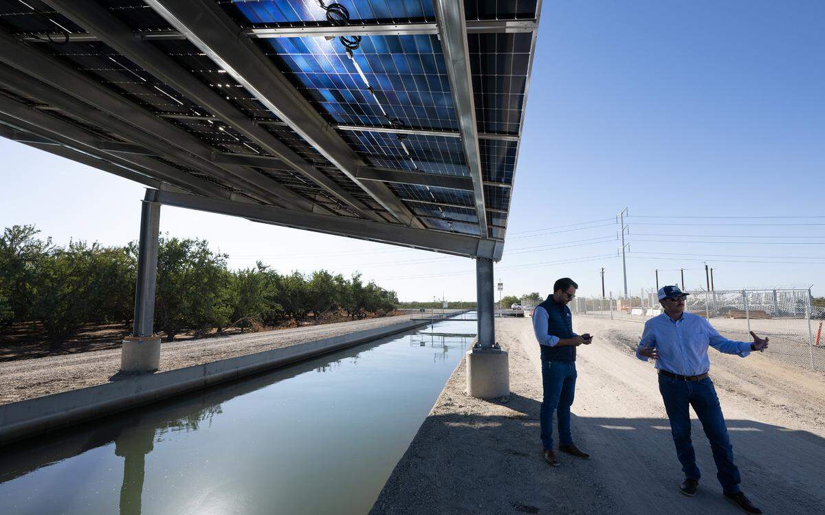 Project manager Bill Penney, right, and Josh Weimer, external affairs director, talk about the design challenges of Project Nexus, a Turlock Irrigation District pilot project using solar arrays to cover two TID canals southwest of Keyes, Thursday, Oct. 17, 2024.
