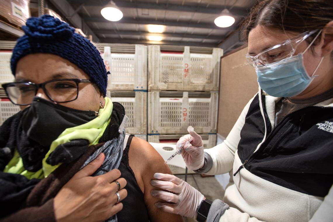 Employee Ofelia Herrera receives the COVID-19 vaccine from CNA Lexi Carmo, right, at Duarte Nursery in Hughson, Calif., on Wednesday, March 17, 2021. 1,000 doses of the Pfizer vaccine were provided by the California Food and Agriculture Administration.