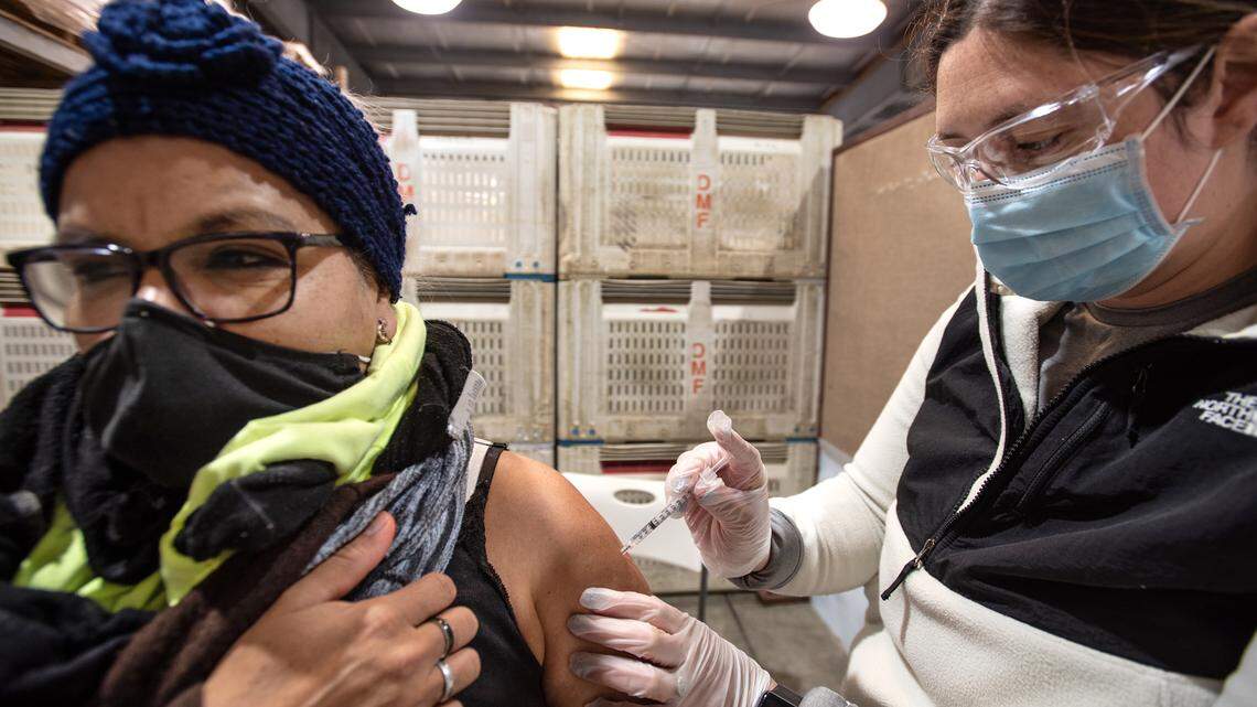 Ofelia Herrera receives the COVID-19 vaccine from Lexi Carmo, right, at Duarte Nursery in Hughson on March 17, 2021.