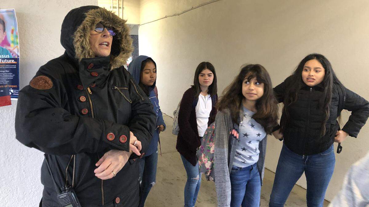 Bundled up for the cold and rain, Shackelford Elementary School Principal Sue McHann greets students and parents Monday morning, March 16, 2020. Because the announcement was made Sunday, she was letting families know schools will close starting Thursday.