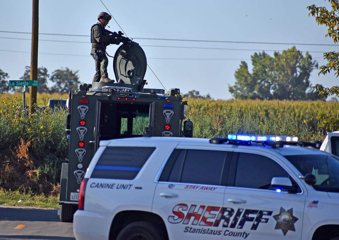 A sheriff’s deputy keeps watch for his colleagues as they serve a search warrant at a 13-greenhouse marijuana grow at a residence on Monterey Avenue in the Monterey Park Tract south of Modesto, Calif. on Thursday morning, Sept. 19, 2019.