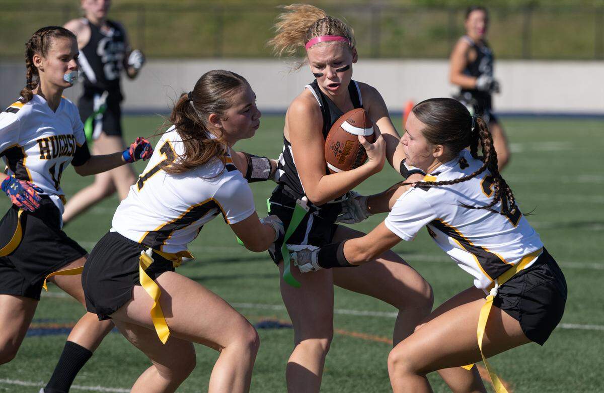 Hughson players Raegan Barstow (7) and Presley Wells (2) swarm Colfax quarterback Kaylee Fore during the Sac-Joaquin Section Division 4 championship game at Cosumnes River College in Sacramento, Saturday, Nov. 9, 2024.