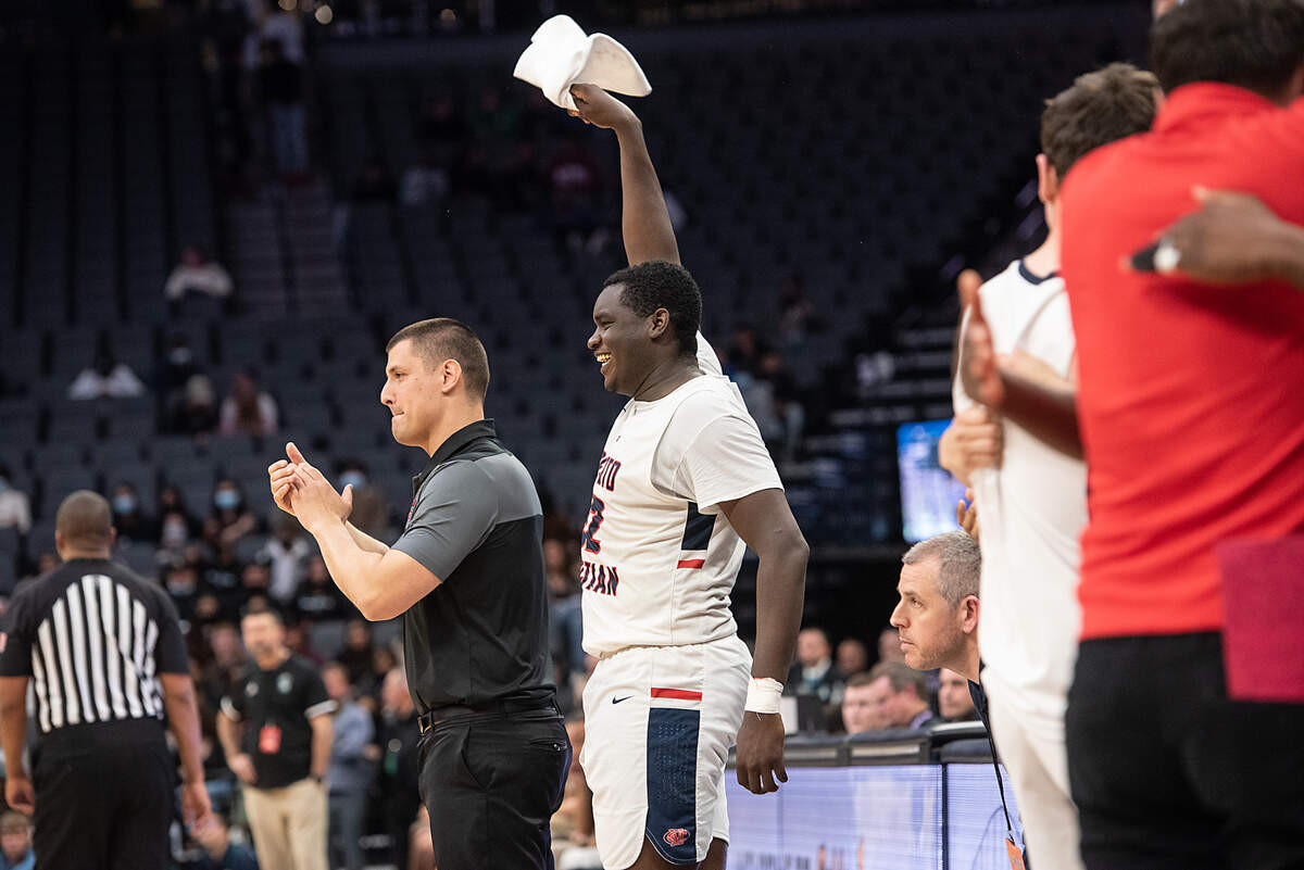 Modesto Christian’s Manasse Itete and coach Brice Fantazia celebrate a basket at the end of the Sac-Joaquin Section Division 1 boys basketball championship game with Sheldon at the Golden 1 Center in Sacramento, Calif., on Saturday, Feb. 26, 2022. Modesto Christian won the game 52-42.