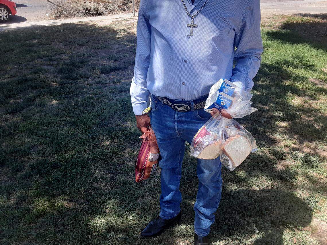A man shows the two meals he received Friday from the USF truck in the Modesto park: Peanut butter and jelly sandwiches, raspberry yogurt, pretzels and milk. The truck also was handing out 5-pound bags of potatoes.