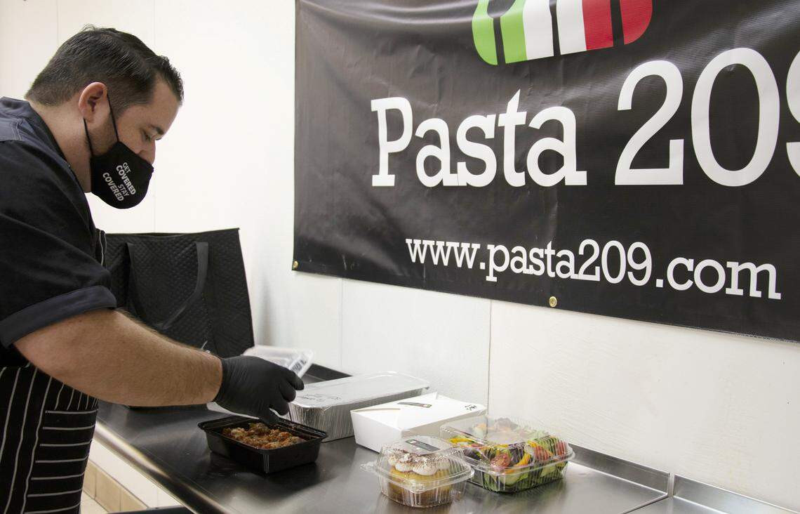 Chef/owner Jason Buktenica shows a family style order from his ghost kitchen restaurant Pasta 209 in Gustine, Calif. Feb. 18, 2021.
