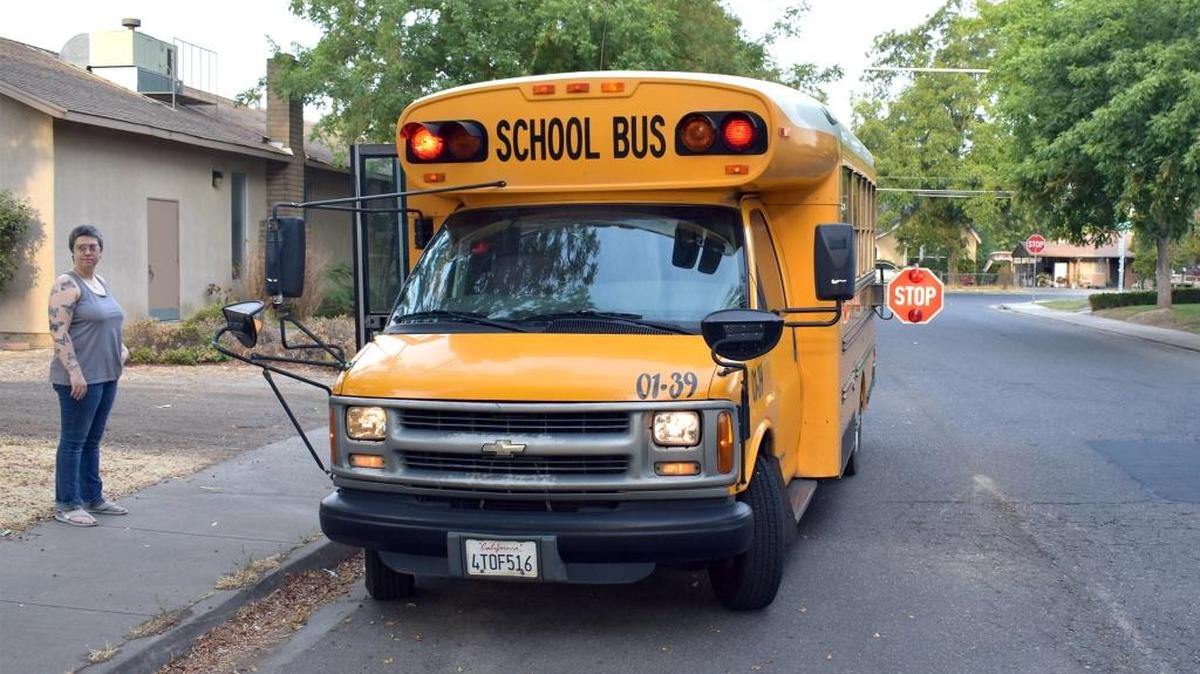 Vera Keane watches for oncoming cars as her daughter Josephine is buckled into her school bus seat on Glenwood Drive the morning of Monday (09-11-17).
