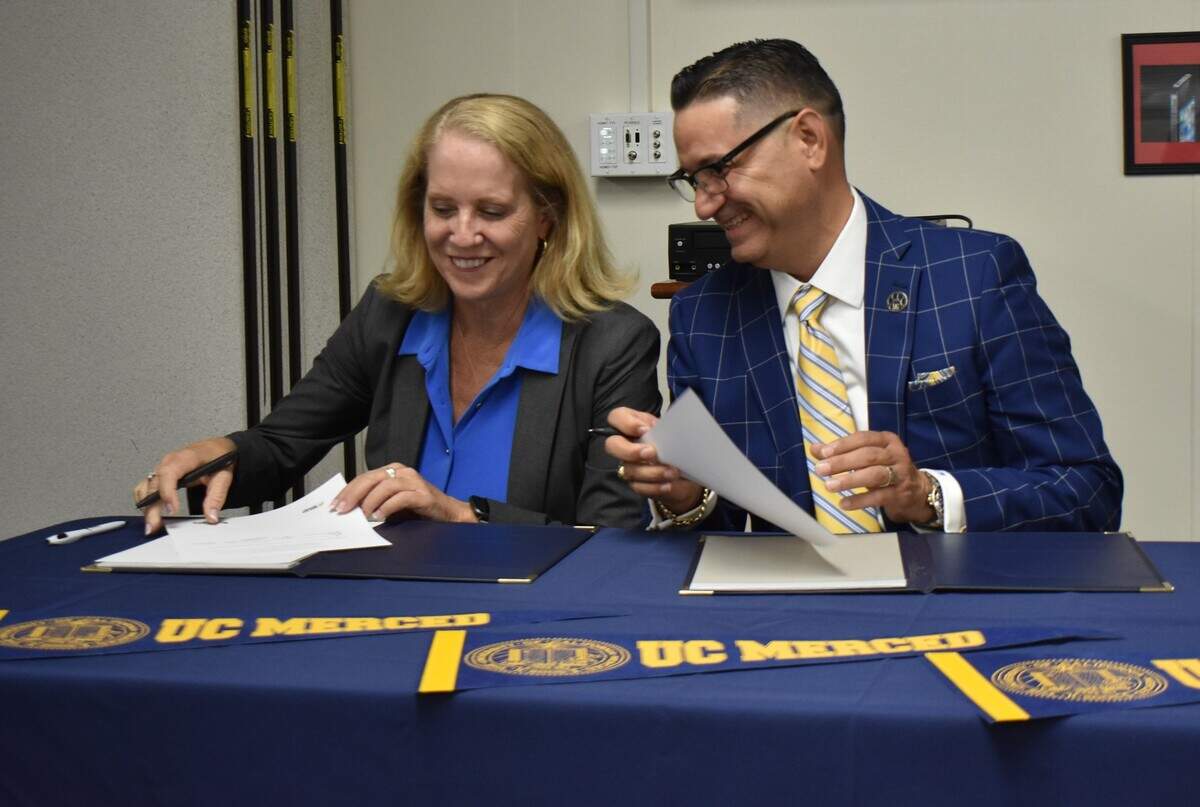 Modesto City Schools Superintendent Sara Noguchi and UC Merced Chancellor Juan Sánchez Muñoz on Tuesday, Sept. 27, 2022, sign an agreement to include the Modesto district in the university’s Merced Automatic Admission Program.