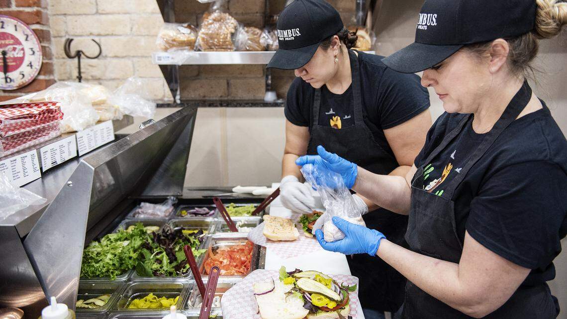 Manager Shawnte Storment, right, and Kyndall Vargas, middle, make sandwiches at The Corral Sandwich Shop in Oakdale, Calif., on Friday, May 1, 2020.