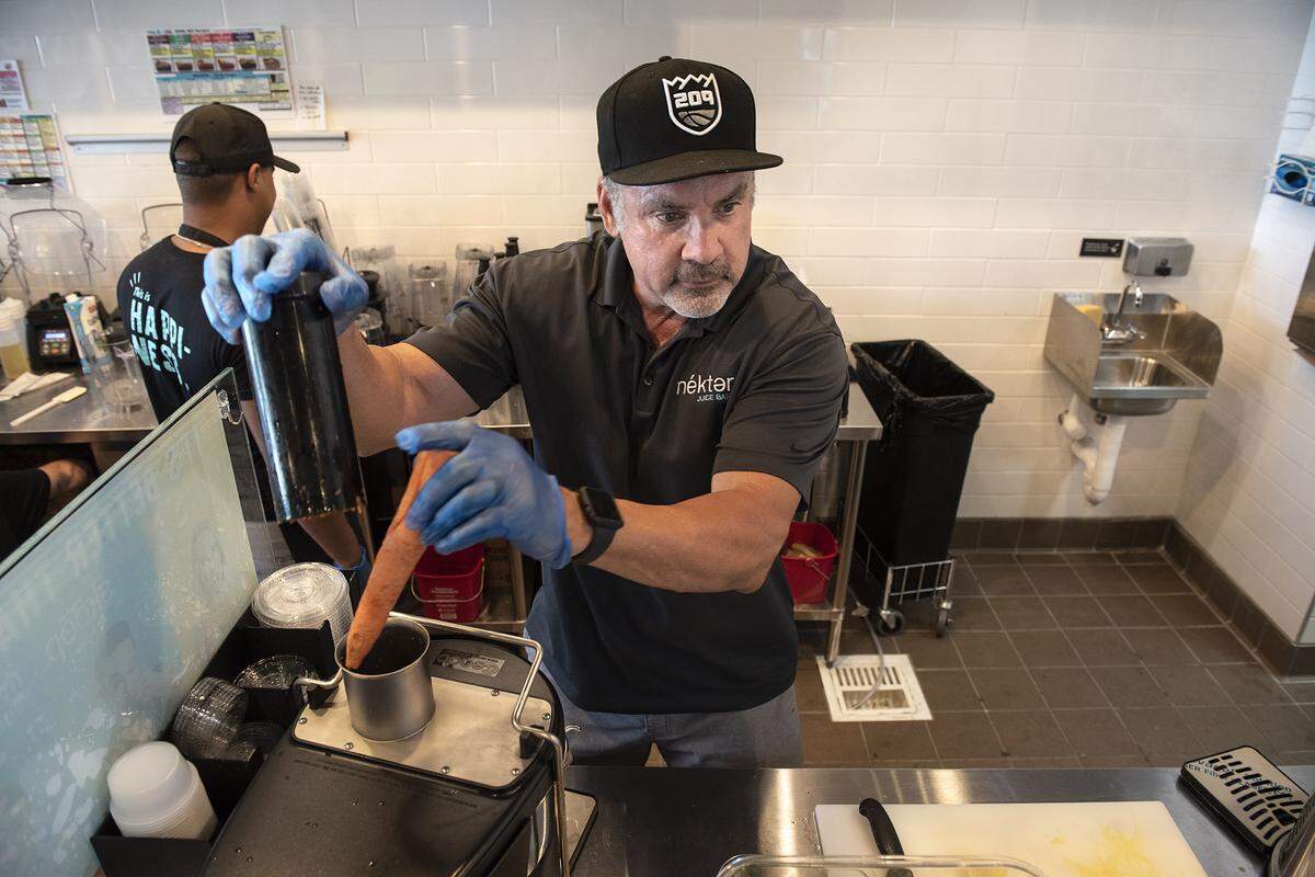 Owner Mark Sarale makes a carrot juice at Nekter Juice Bar in Modesto, Calif., Friday, July 26, 2019.