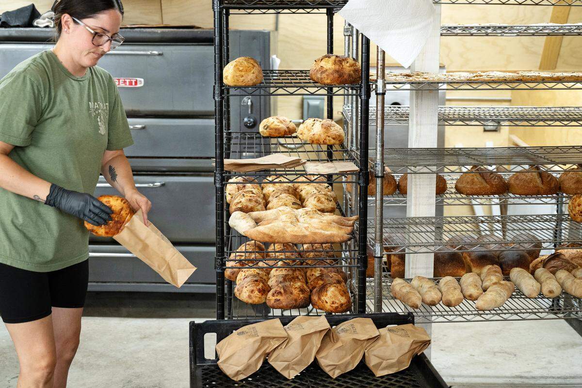 Kayla Martin bags up fresh baked items at the MatKat Sourdough bakery in Oakdale, Calif., Wednesday, July 24, 2024.
