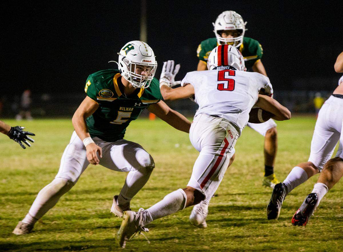 Logan Cardoso, 5, of Hilmar High closes in on Xzavier Clark, 5, of Ripon High as he works his way up field. Ripon vs Hilmar at Hilmar Sept. 23, 2022.