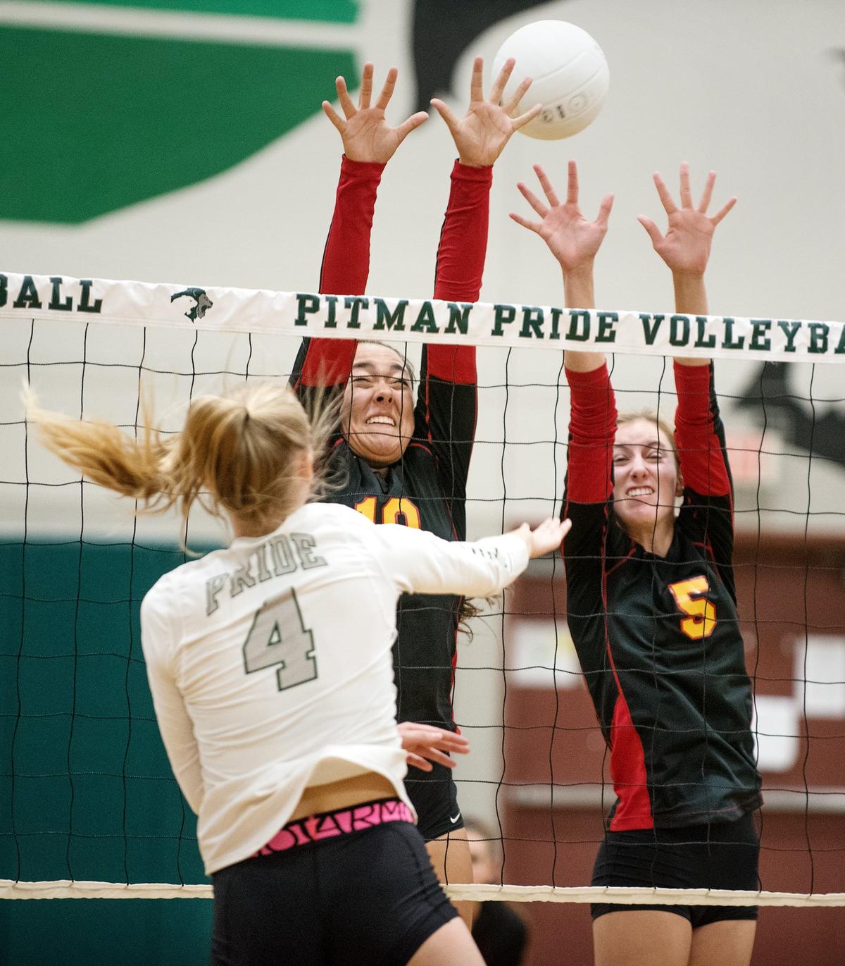 Pitman’s Avery Carlson (4) spikes the ball past Oakdale’s Grace Verdegaal (5) and Emma Harper (10) during Thursday’s match at Pitman High School n Turlock, Calif., August 30, 2018.