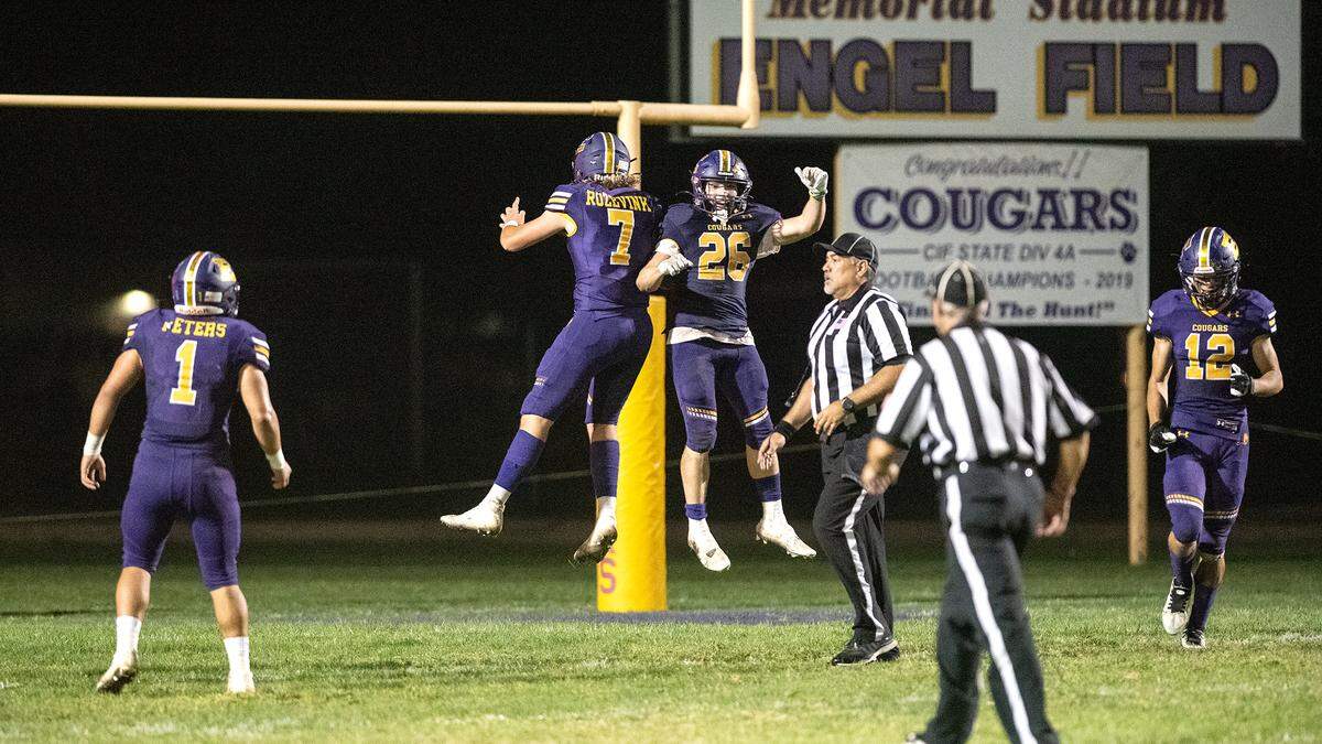 Escalon players Jamin Miller (26) and Donovan Rozevink (7) celebrate an interception and touchdown during the Trans-Valley League game in Escalon, Calif., Thursday, Oct. 6, 2022.