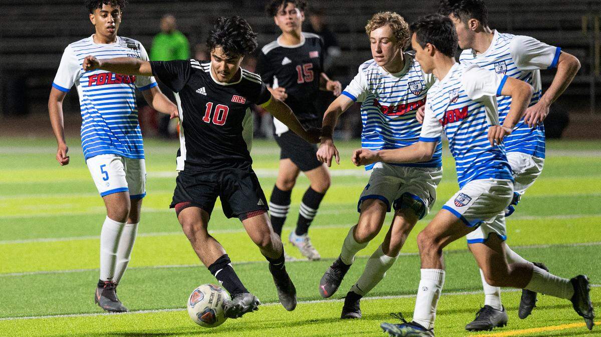 Modesto’s Alexis Luna tries to evade Folsom defenders near the goal during the Sac-Joaquin section playoff game at Downey High School in Modesto, Calif., on Thursday, Feb. 10, 2022. Luna scored all three goals in Modesto’s 3-0 victory.
