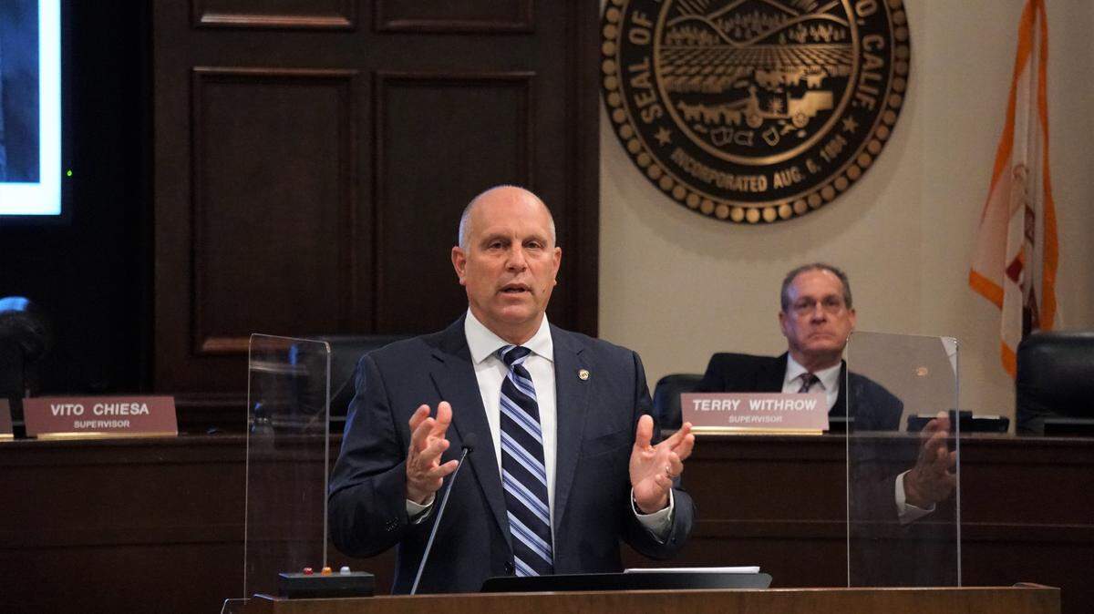 El presidente de la Junta de Supervisores del Condado de Stanislaus, Vito Chiesa, con el supervisor Terry Withrow al fondo, pronuncia su discurso sobre el Estado del Condado de 2021 en el Tenth Street Place, en Modesto, California, el martes 2 de marzo de 2021.