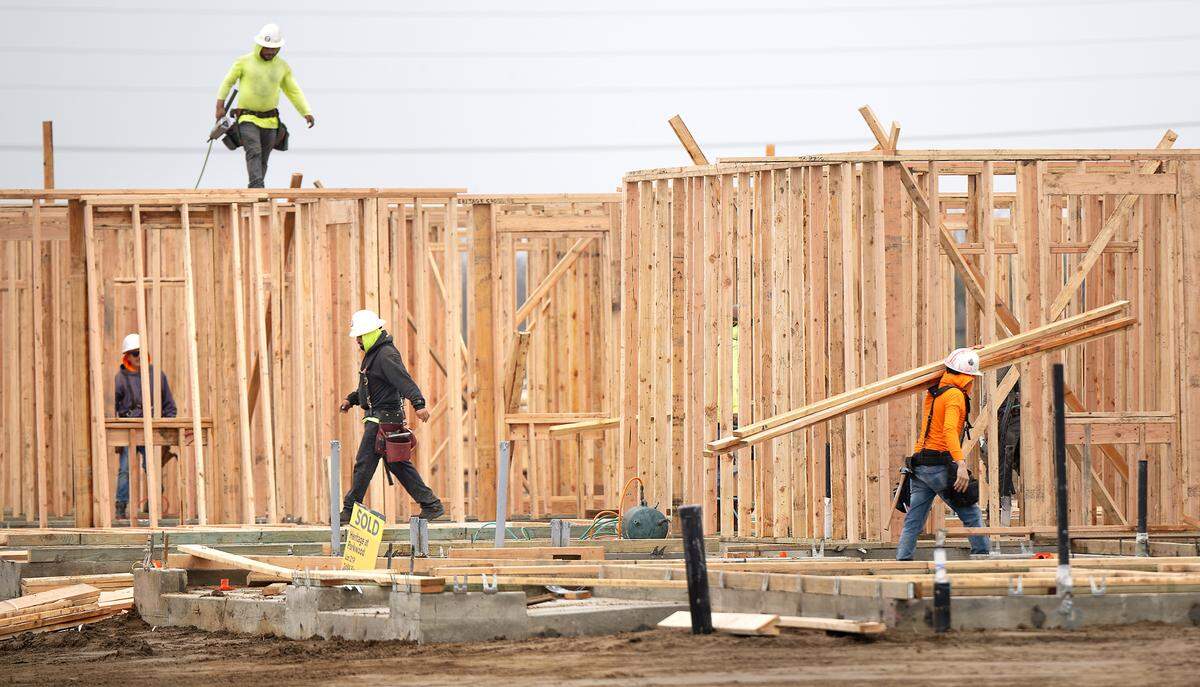 Workers frame new homes at Heritage at Parkwood housing development in Hughson, Wednesday, Dec. 18, 2024.
