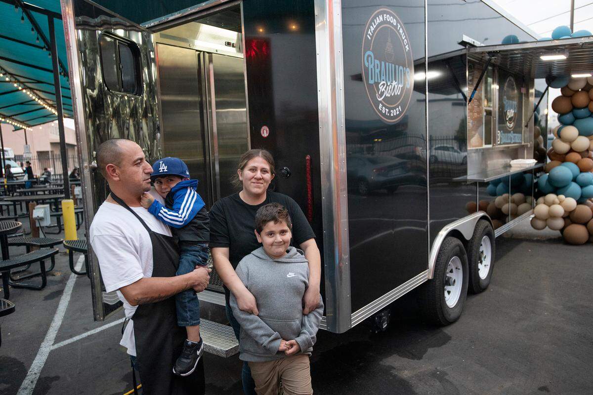 Italian food truck Braulio’s Bistro owners Braulio Hernandez and Kathy Ramirez with theirs sons Julian, 3, and Adrian, 7, take a break outside their trailer at Grub Hubs food truck court in Modesto ,Calif., on Thursday, Nov. 18, 2021.