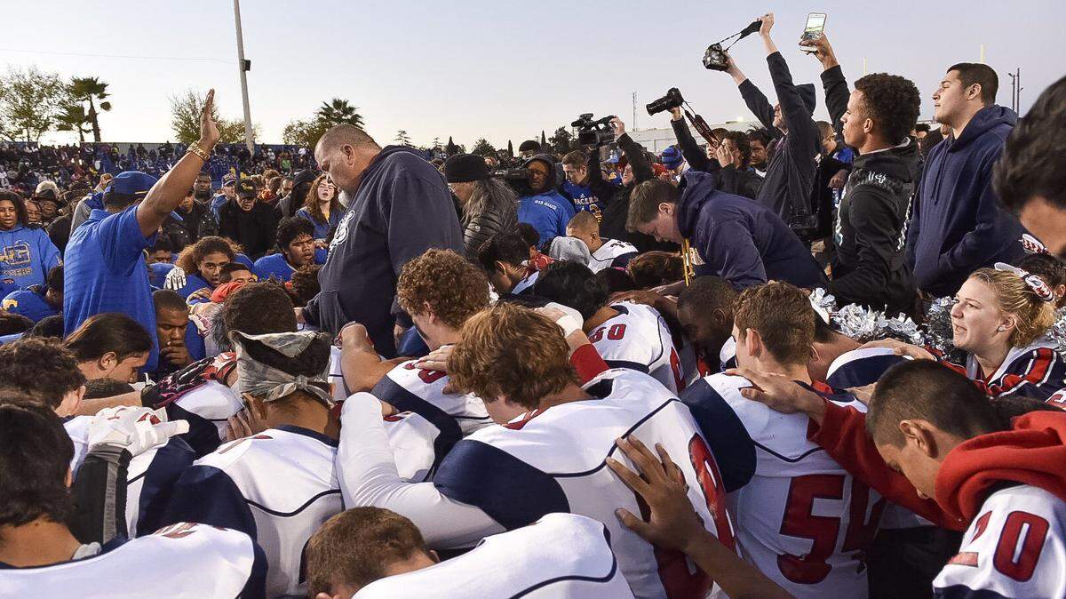 For five weeks, win or lose, coach Doug Severe and the Beyer High football team have huddled with members of the opposing team for a quick postgame prayer.  Along with blessings of protection and success, Severe, shown here praying with players from Beyer and Grant high schools, hopes the players take home an even greater message: Despite our differences, we can still come together.