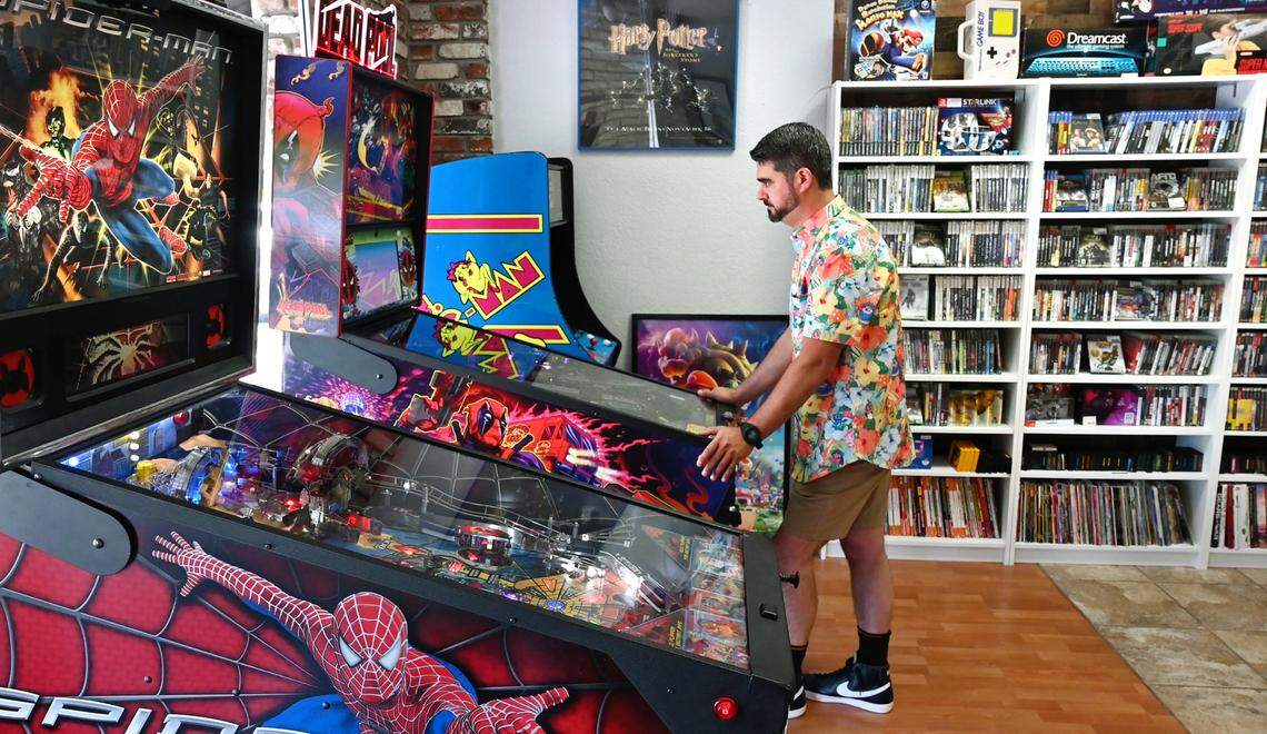 Laughing Crow Collectibles owner Jerod Pimentel plays pinball at his shop in Roseburg Square in Modesto, Calif., Thursday, May 2, 2024.