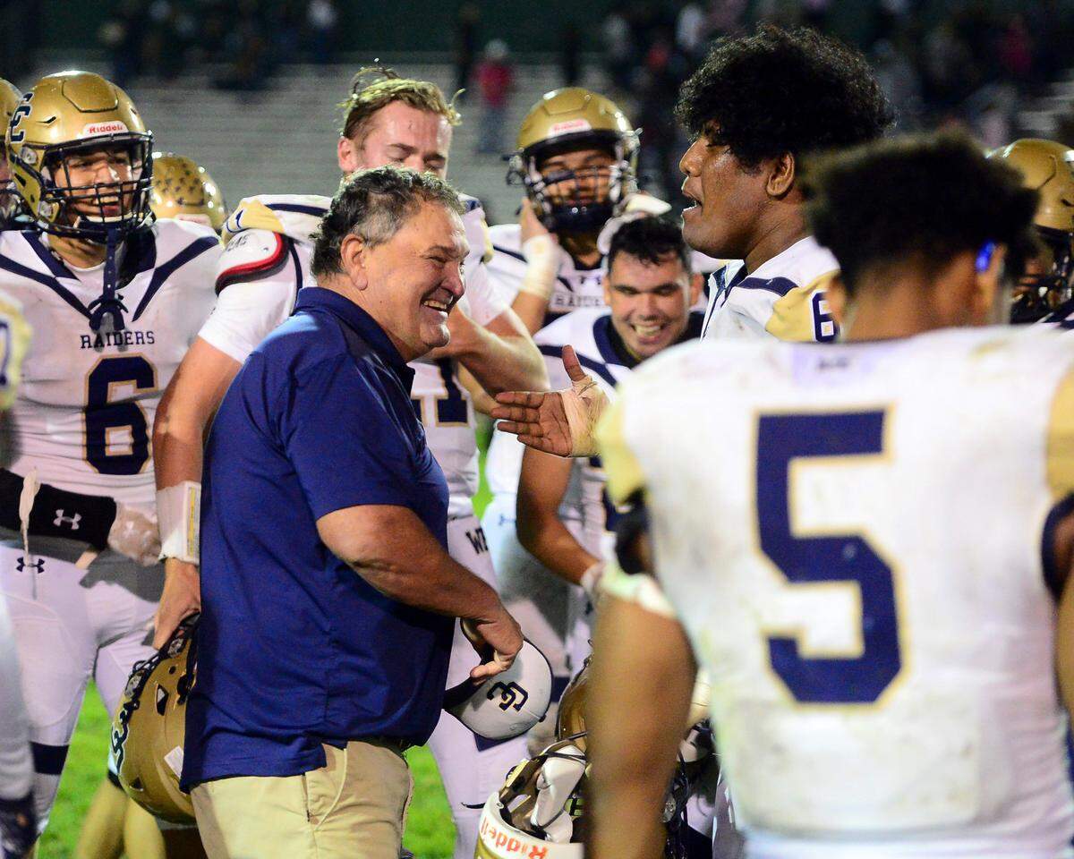 Central Catholic Head Coach Rodger Canepa celebrates with his team after beating Manteca in Manteca California on October 22, 2022. Central Catholic won the game 56-49.