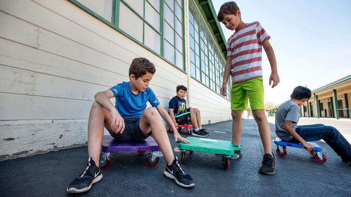 Twins Joshua and Jason Bowers, 10, play outside with Ricardo Godinez and Miguel Fararjo, right, during Modesto Schools sponsored child care program at Muir Elementary School in Modesto, Calif., on Tuesday, April 14, 2020. Modesto City Schools has been aiding health care workers, public safety first responders and its own nutrition services employees with free child care at one of its centrally located elementary campuses.
