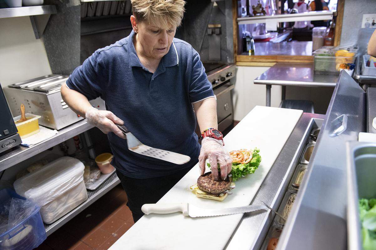 Owner Lorena Loftis prepares an Impossible Burger, meatless burger, at Deva Cafe in Modesto, Calif., Saturday, April 20, 2019.