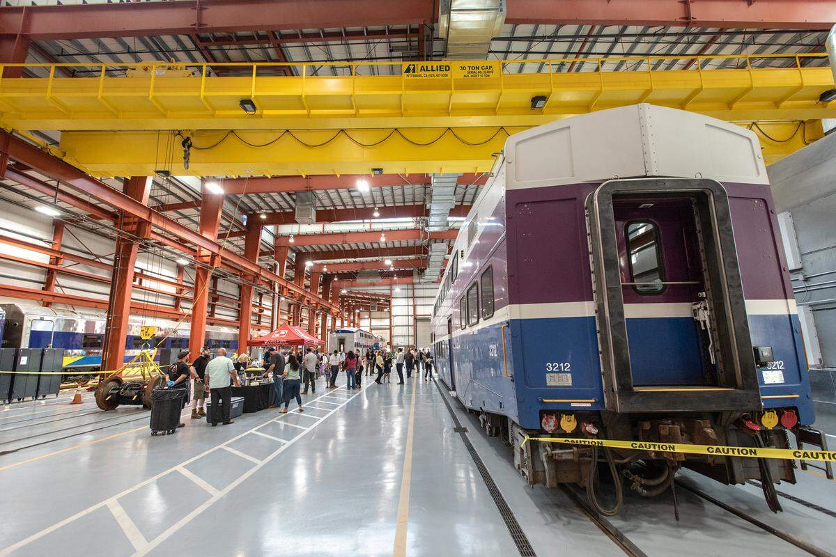 People gathered at the Altamont Corridor Express maintenance facility for an open house to announce the creation of the Rail Academy of Central California in Stockton, Calif., on Wednesday, May 25, 2022. The program will launch in August, with classroom training at a community college and hands-on work at the ACE maintenance facility.